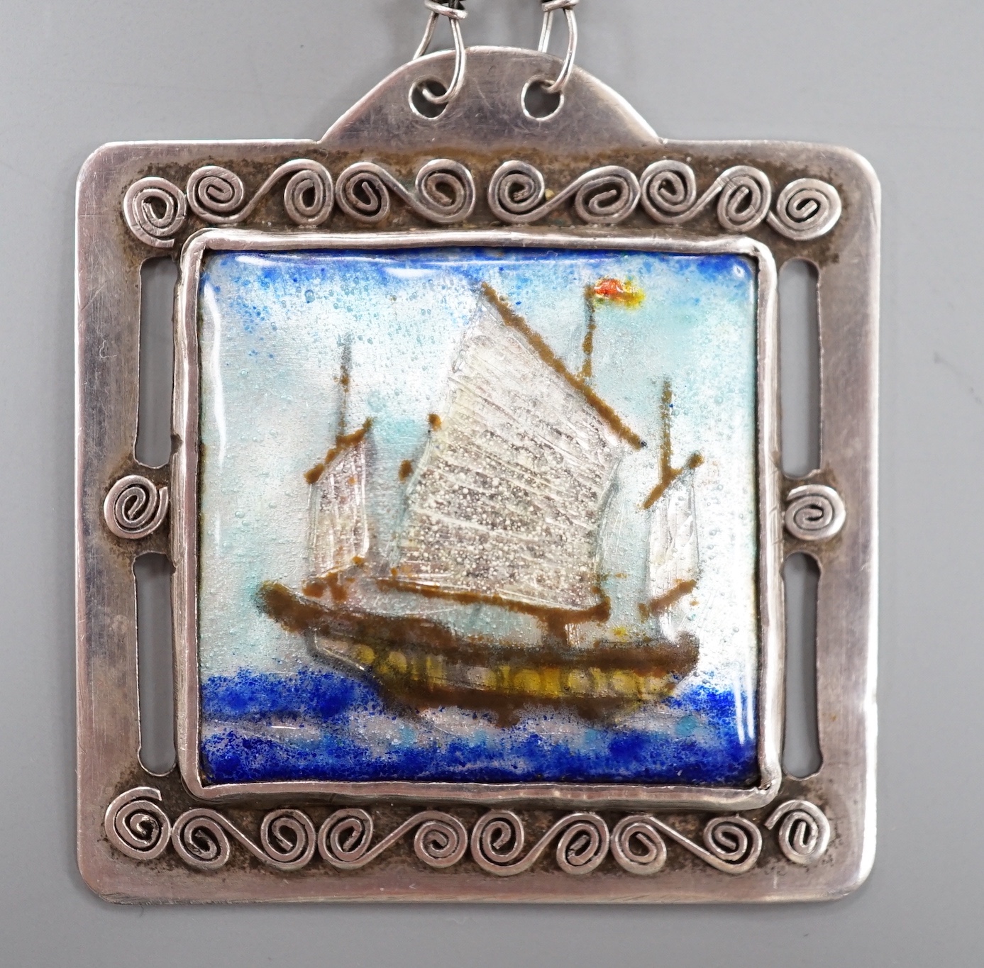 A continental white metal and polychrome enamel square pendant on chain, pendant 42mm, maker EK?.